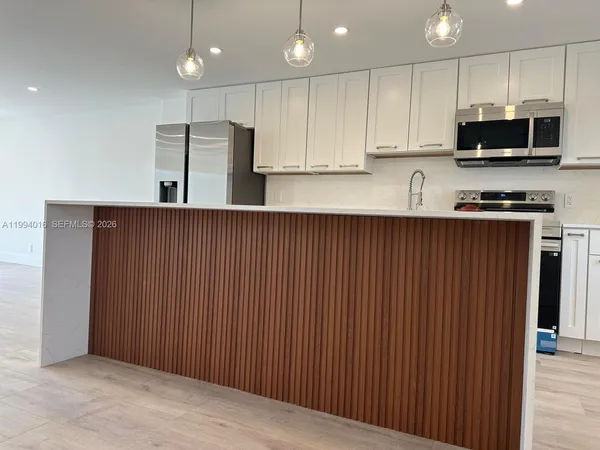 a kitchen with stainless steel appliances a refrigerator sink microwave and cabinets