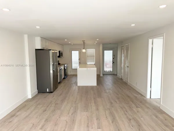 a view of a refrigerator in kitchen and a window