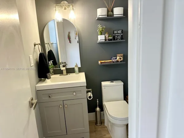 a bathroom with a toilet sink vanity and mirror