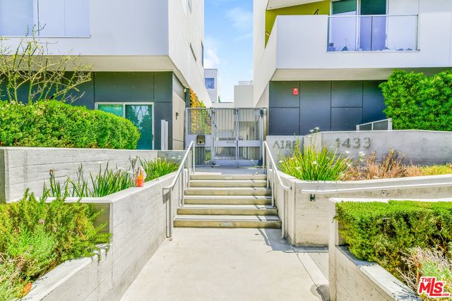 a front view of a house with a garden and plants