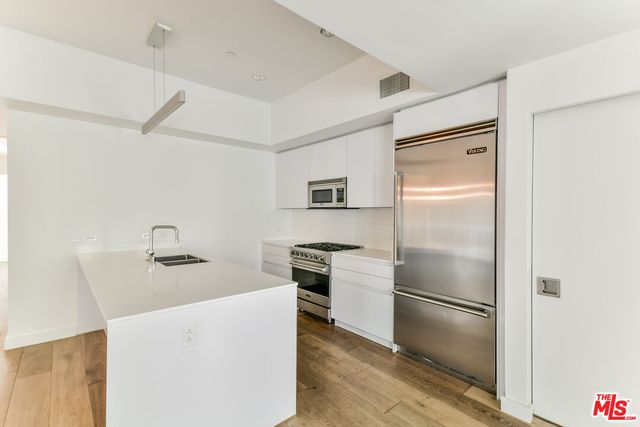 a kitchen with a sink cabinets and a wooden floor