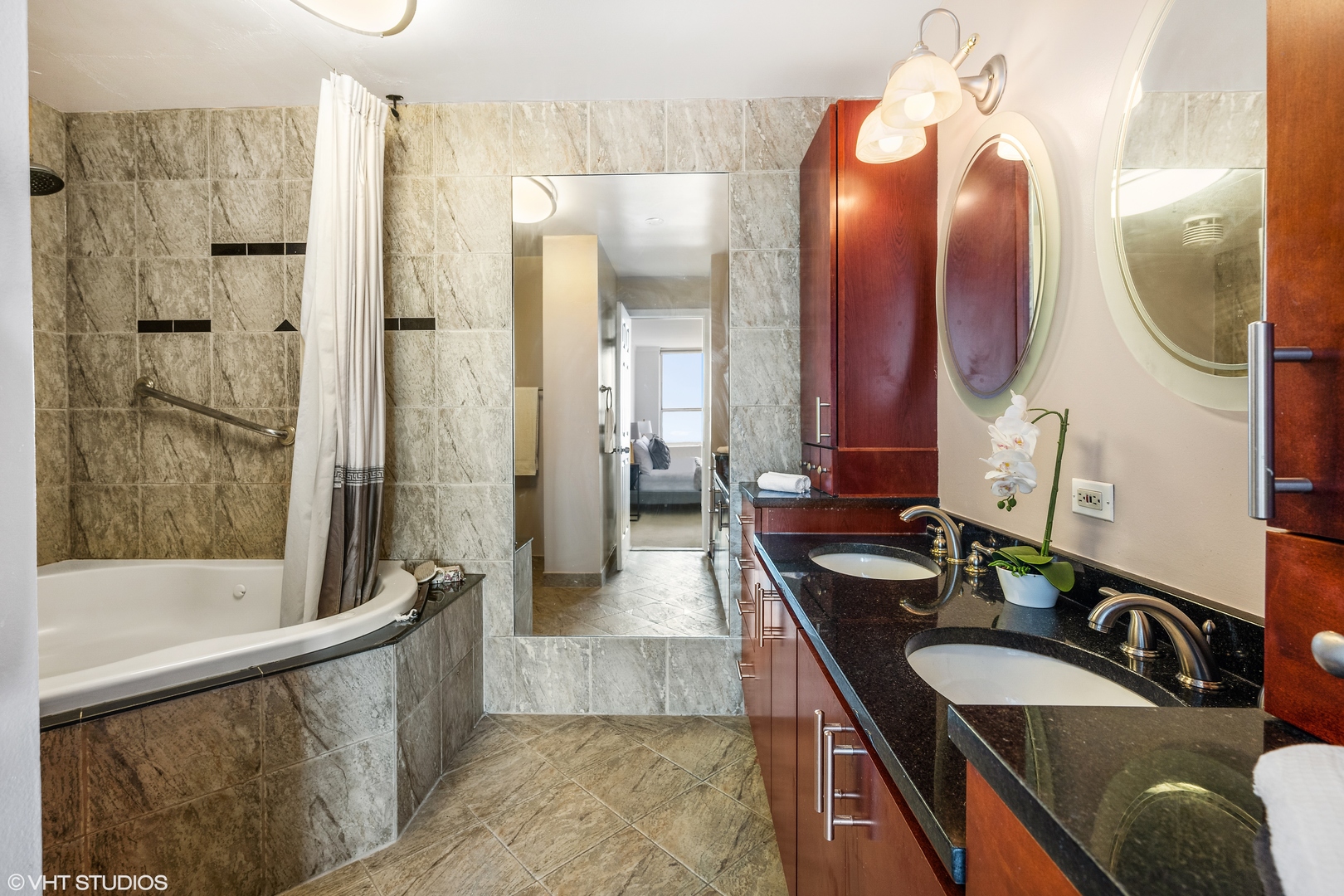 655 West Irving Park Road, Unit 5301 Chicago, IL 60613 - Photo 12 of 20 a bathroom with a granite countertop tub a double vanity sink a vanity and a mirror
