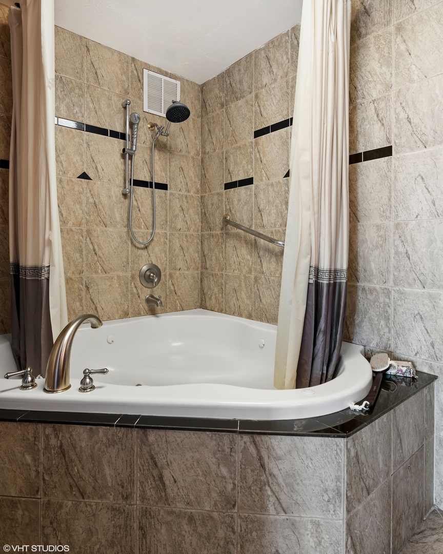 655 West Irving Park Road, Unit 5301 Chicago, IL 60613 - Photo 13 of 20 a bathroom with a bathtub and a shower