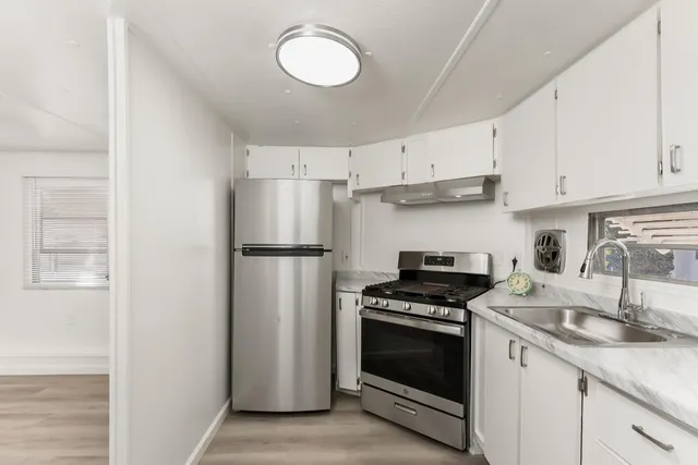 a kitchen with cabinets stainless steel appliances and a sink