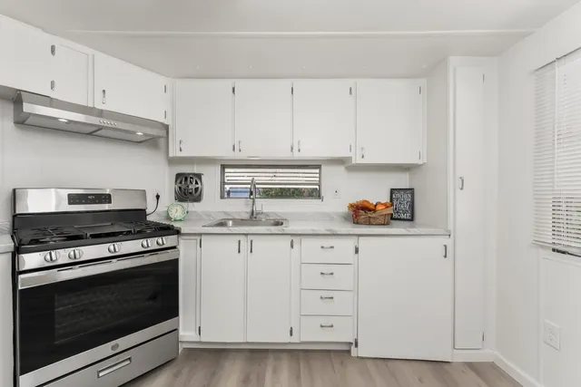 a kitchen with white cabinets and appliances