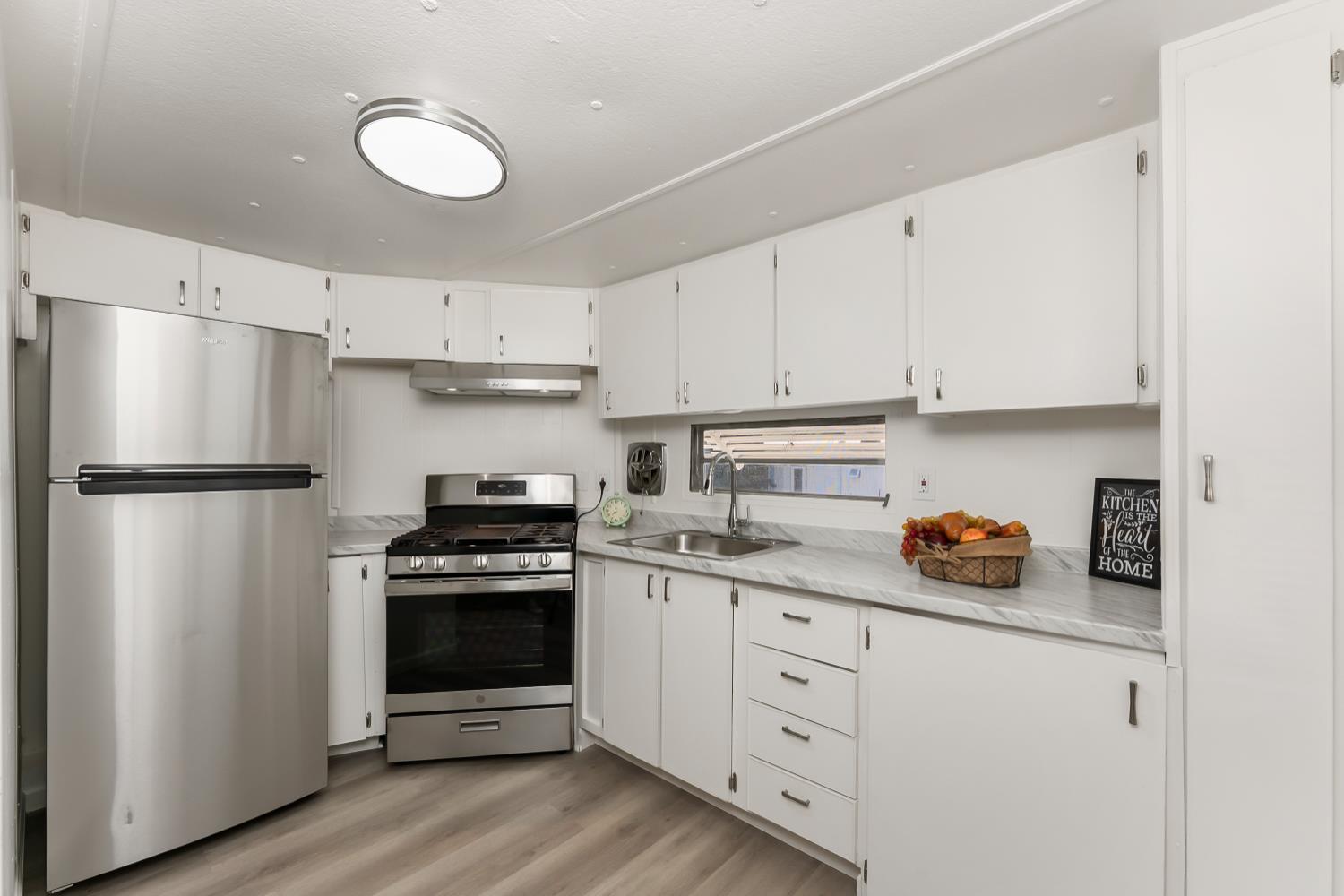 1525 Cold Springs Road, Unit 48 Placerville, CA 95667 - Photo 10 of 44 a kitchen with white cabinets and stainless steel appliances