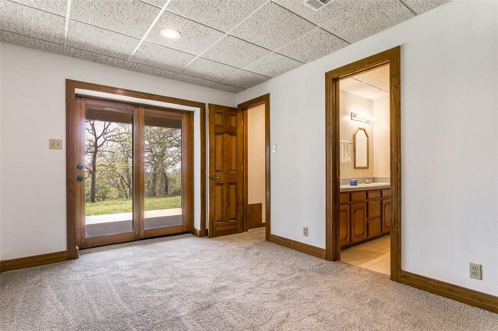 1557 Latigo Hills Road Bartonville, TX 75022 - Photo 29 of 40 Doorway to outside featuring a drop ceiling and carpet floors