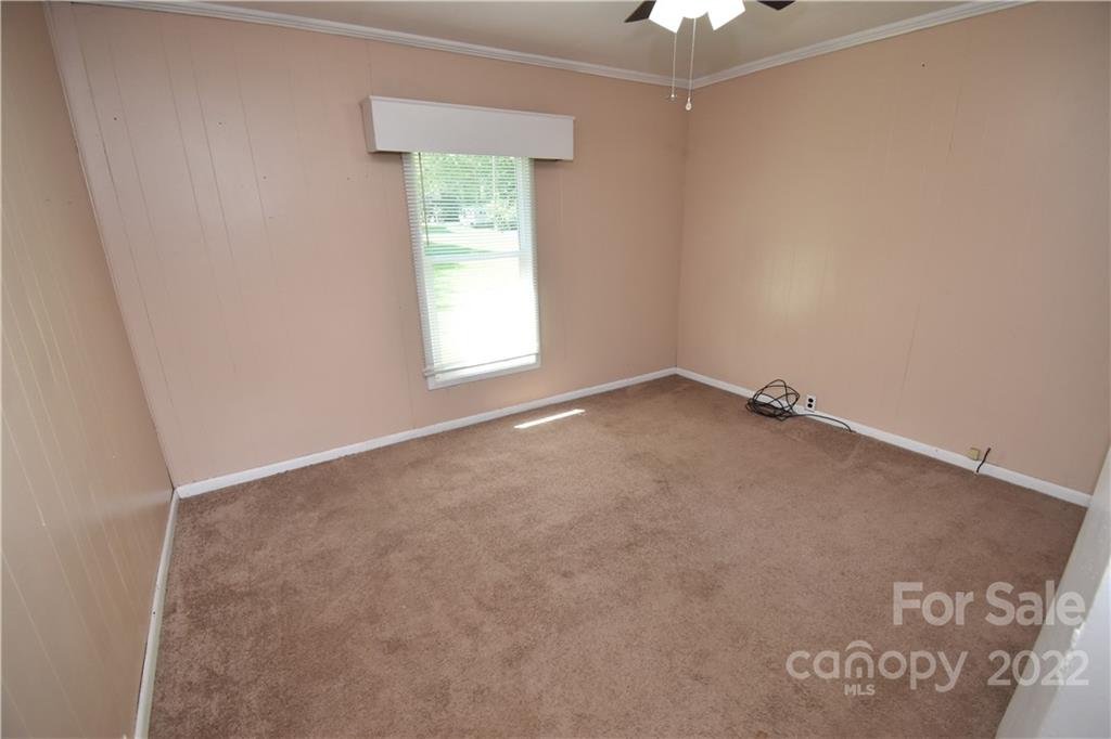 210 Proctor Street Lincolnton, NC 28092 - Photo 13 of 19 an empty room with a ceiling fan and a window