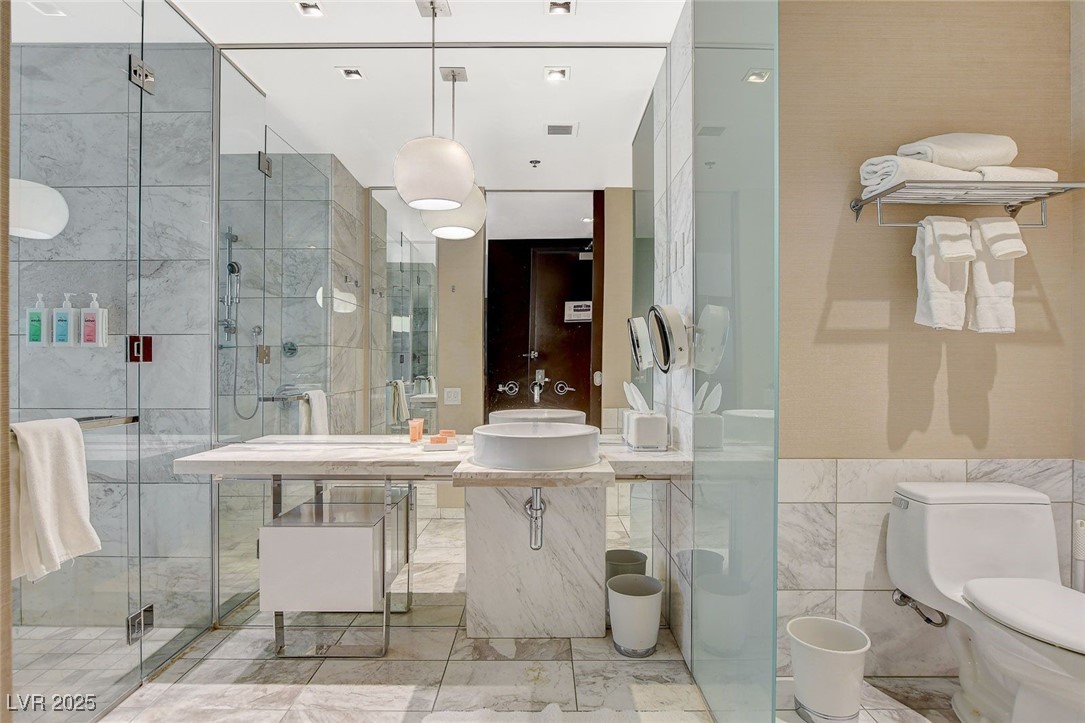 4381 West Flamingo Road, Unit 2204 Las Vegas, NV 89103 - Photo 18 of 27 Bathroom with tile walls and a shower stall