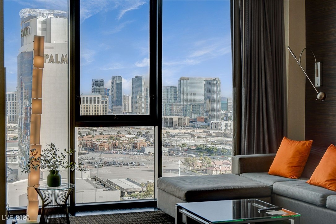 4381 West Flamingo Road, Unit 2204 Las Vegas, NV 89103 - Photo 25 of 27 Living room with healthy amount of natural light, a skyline view, and a wall of windows