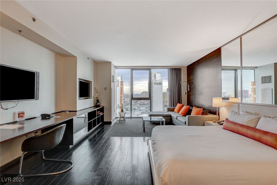 4381 West Flamingo Road, Unit 2204 Las Vegas, NV 89103 - Photo 3 of 27 Bedroom with floor to ceiling windows, dark wood-style flooring, access to outside, and a desk