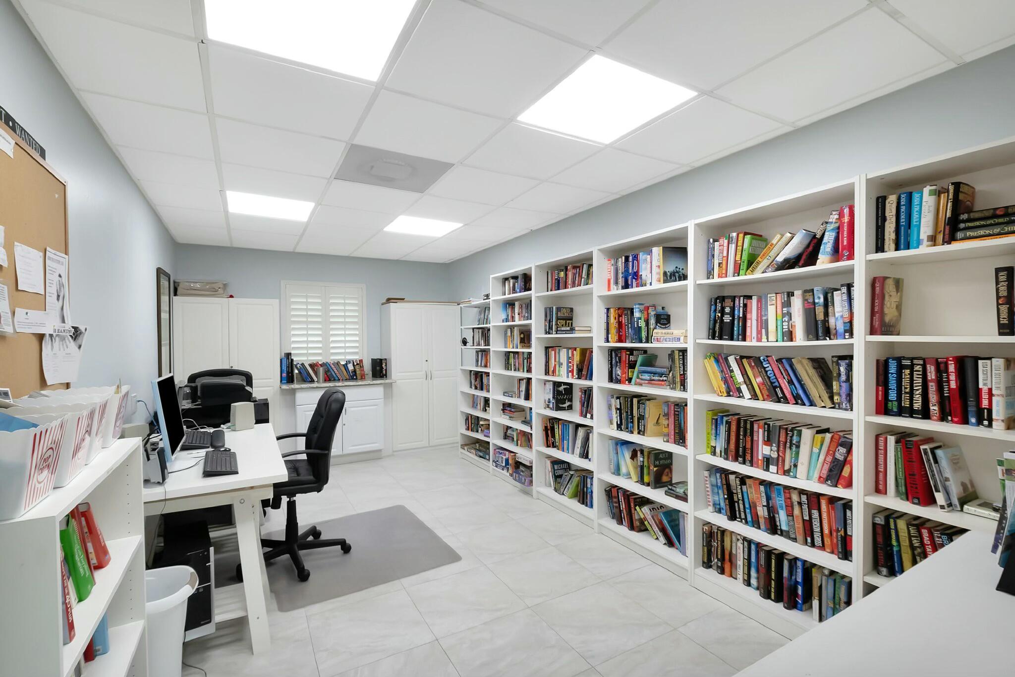 2320 Southwest 22nd Avenue, Unit 211 Delray Beach, FL 33445 - Photo 25 of 38 a view of a livingroom with workspace and a bookshelf