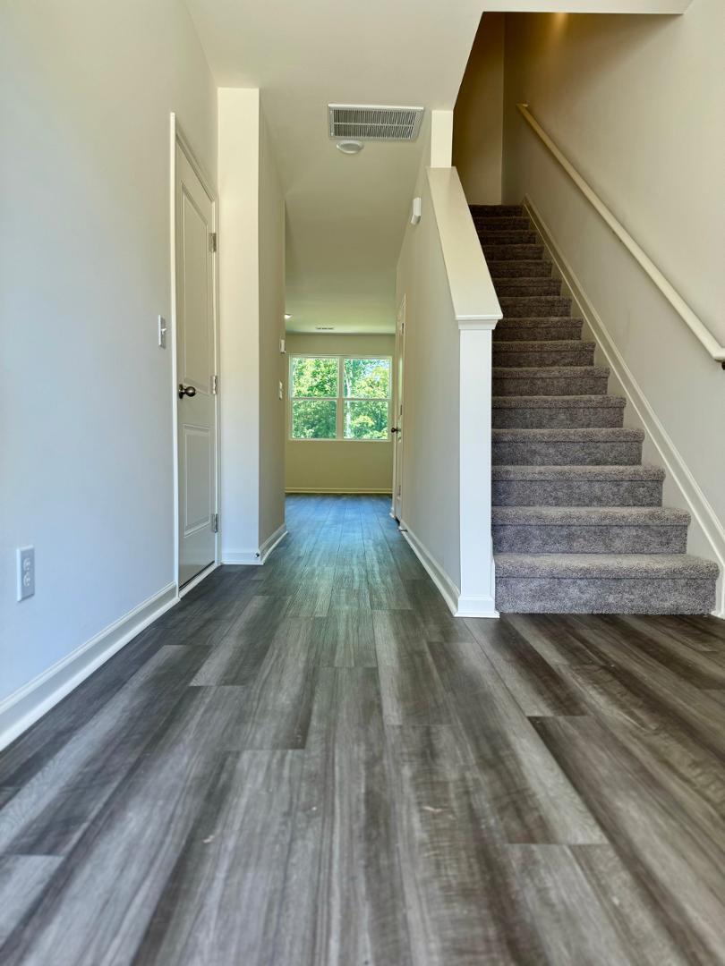 3117 Primo Drive Durham, NC 27704 - Photo 4 of 23 a view of a hallway with wooden floor and staircase
