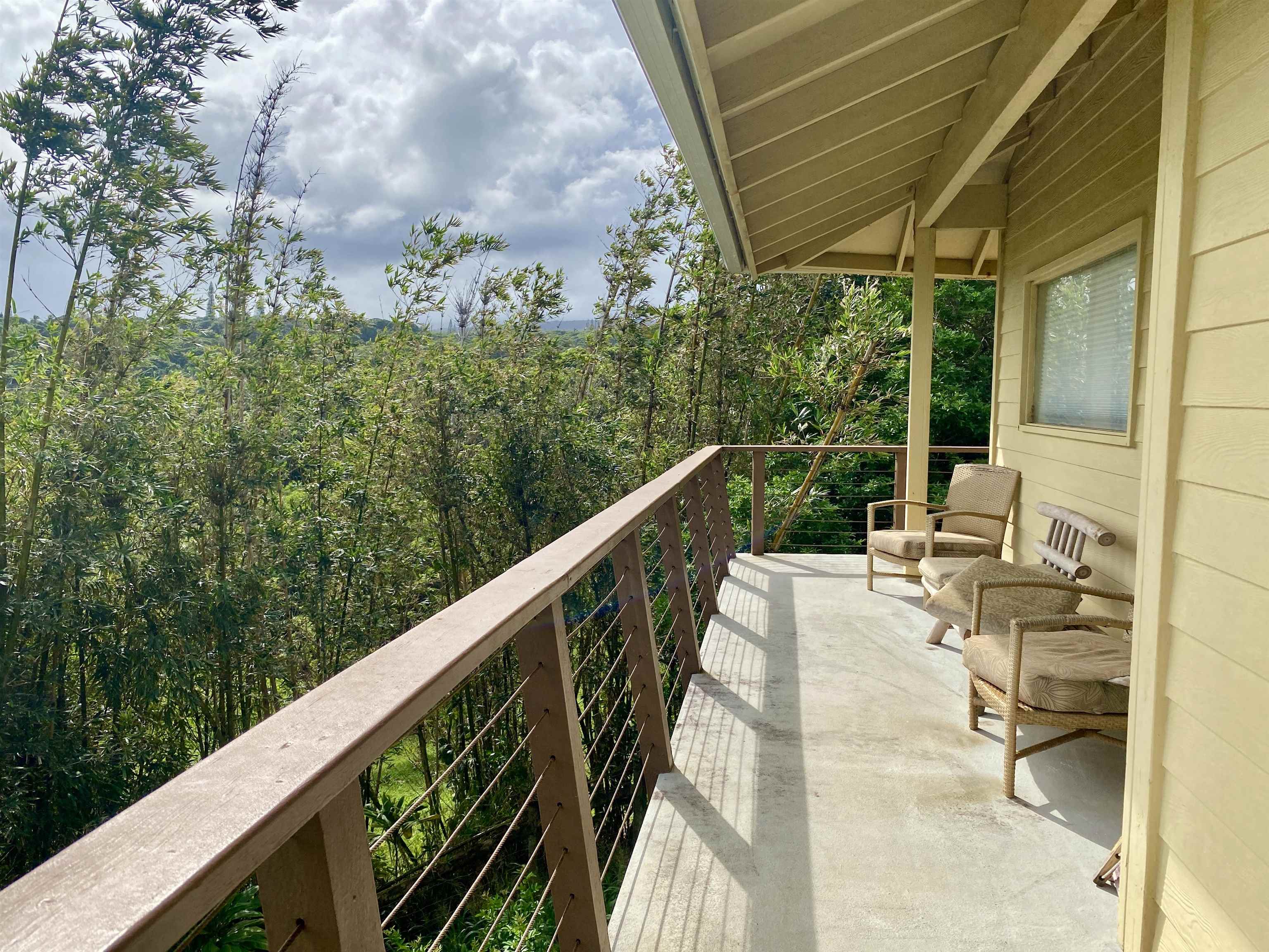 700 Honopou Road, Unit 700 HONOPOU RD Haiku, HI 96708 - Photo 14 of 50 a balcony with wooden floor and outdoor seating