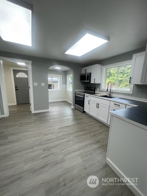 1244 Cedar Street Raymond, WA 98577 - Photo 11 of 25 a large kitchen with stainless steel appliances granite countertop a large counter top a stove and a wooden floors