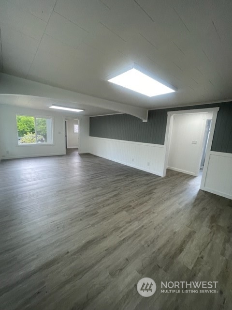 1244 Cedar Street Raymond, WA 98577 - Photo 8 of 25 an empty room with wooden floor and windows