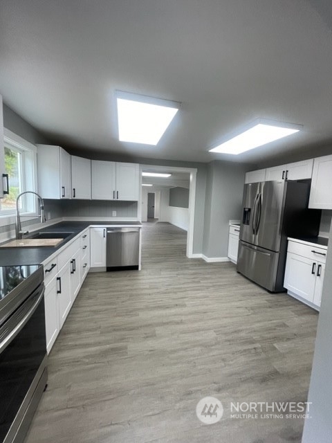 1244 Cedar Street Raymond, WA 98577 - Photo 9 of 25 a large kitchen with stainless steel appliances granite countertop a stove a sink and a refrigerator