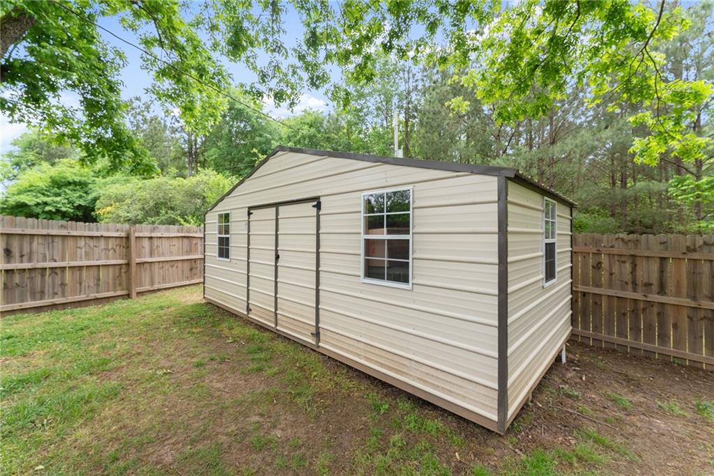 1519 New Hope Church Road Loganville, GA 30052 - Photo 35 of 48 a view of a backyard with a small cabin and wooden fence