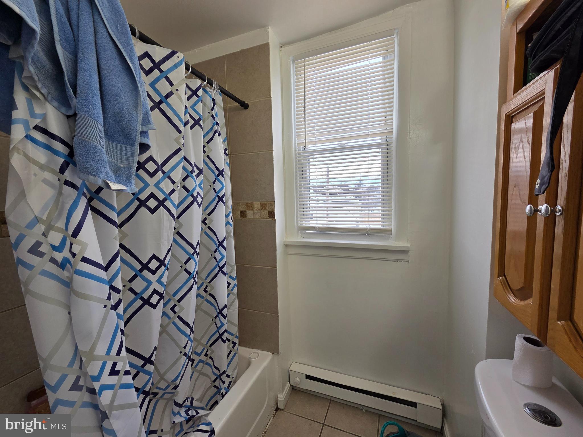 223 Summer Street Hagerstown, MD 21740 - Photo 5 of 15 a bathroom with a shower curtain and a window