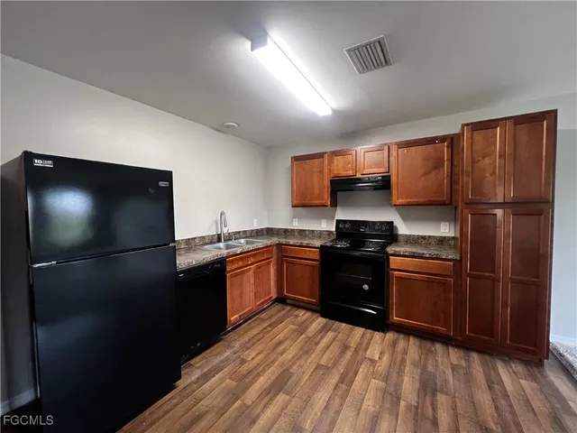 a kitchen with granite countertop stainless steel appliances and a refrigerator