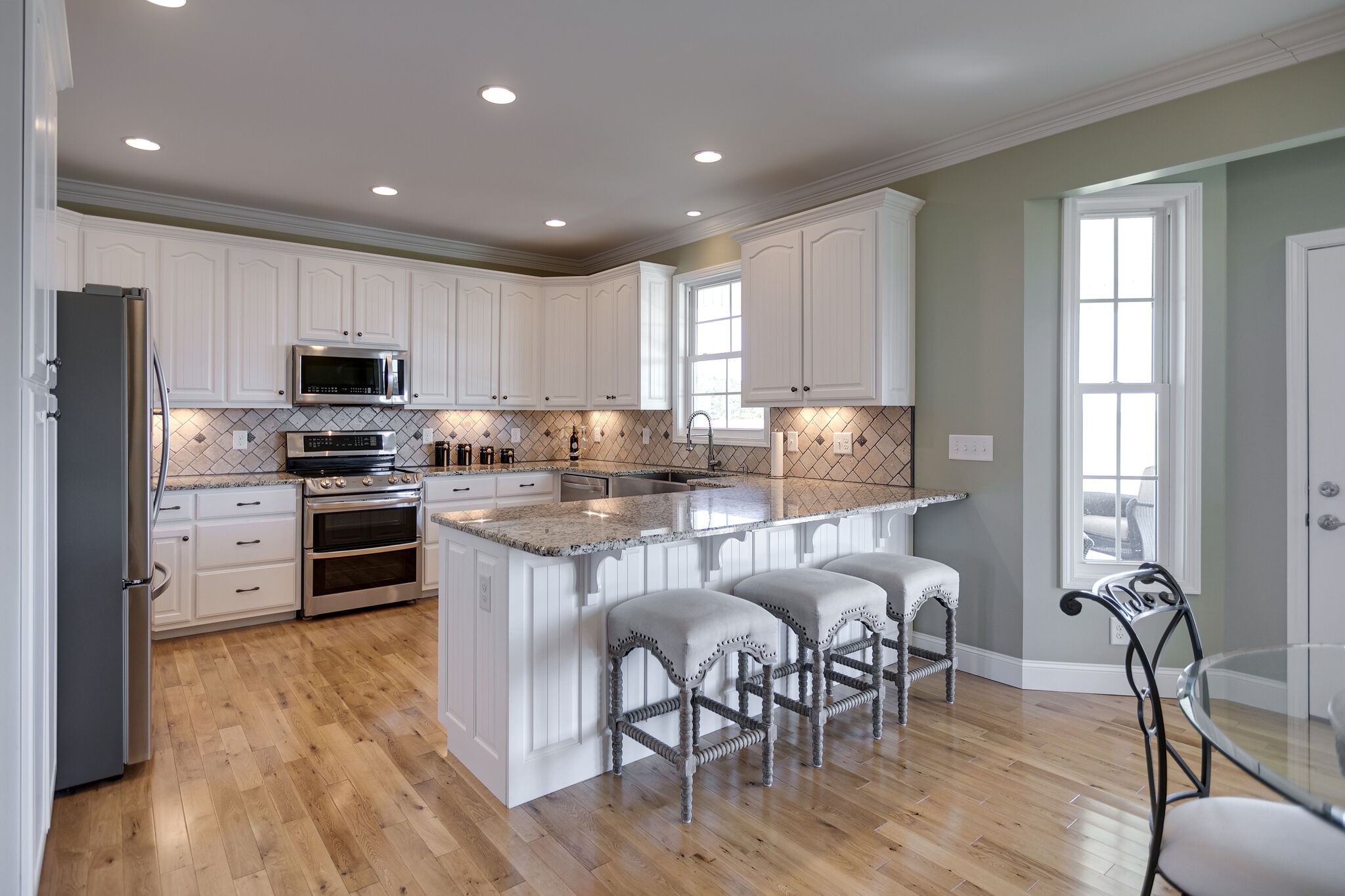 58 Locker Road Summertown, TN 38483 - Photo 5 of 28 a kitchen with stainless steel appliances granite countertop a stove top oven a refrigerator a sink and a dining table with wooden floor