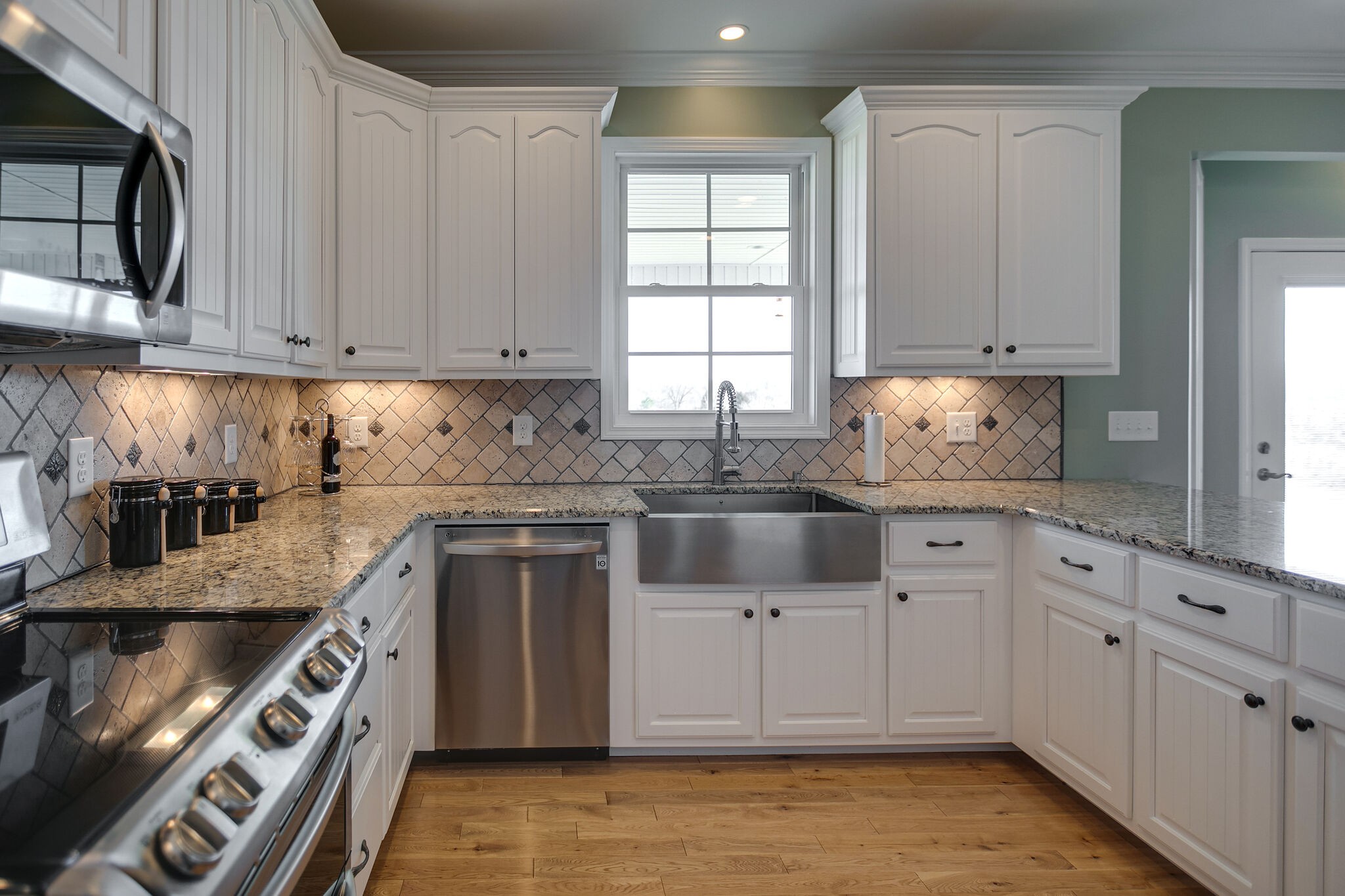 58 Locker Road Summertown, TN 38483 - Photo 6 of 28 a kitchen with granite countertop white cabinets and stainless steel appliances