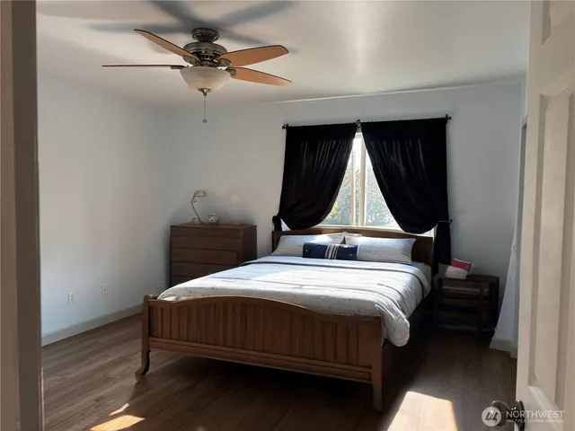 a bedroom with a bed a dresser and a chandelier