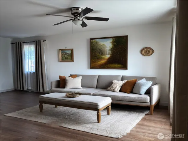 a living room with furniture and a ceiling fan