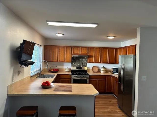 a kitchen with kitchen island granite countertop a sink stainless steel appliances and cabinets
