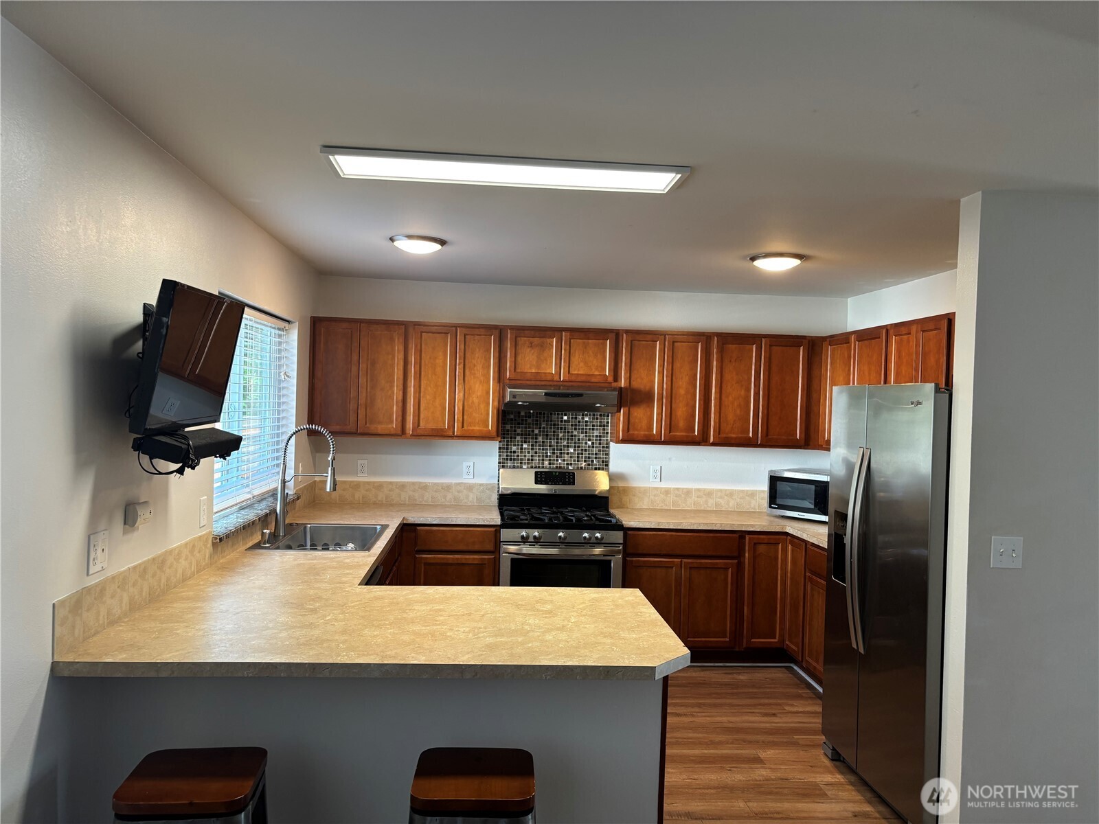 6401 Brycen Lane Southwest, Unit B Olympia, WA 98512 - Photo 7 of 20 a kitchen with kitchen island granite countertop a sink stainless steel appliances and cabinets