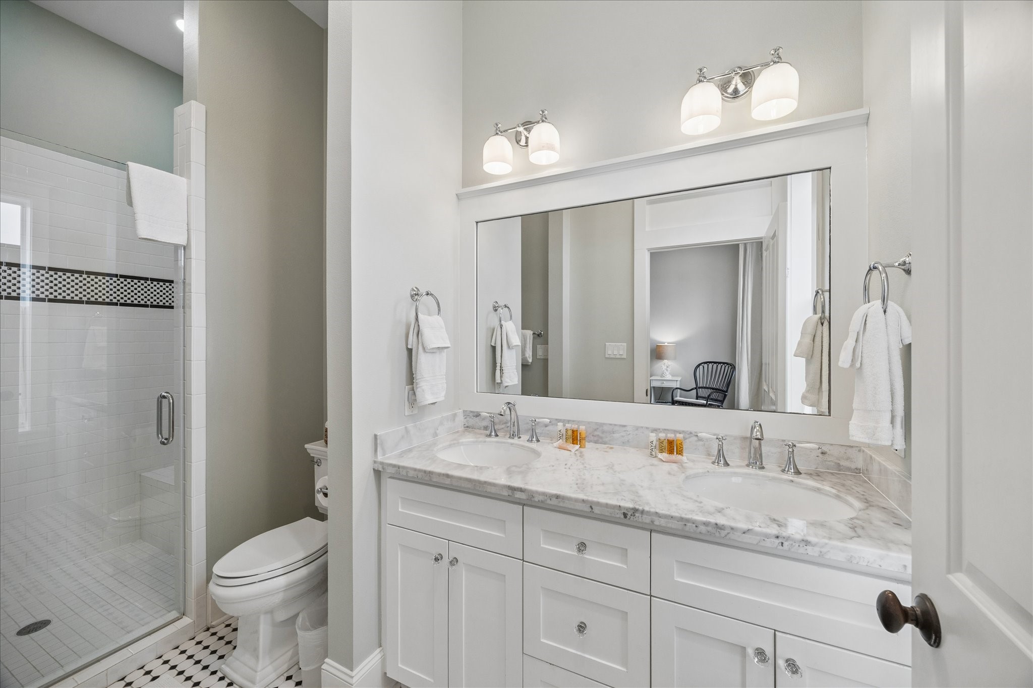 710 Positano Road Galveston, TX 77550 - Photo 18 of 36 Bedroom two features an en suite bathroom and double vanity sinks.