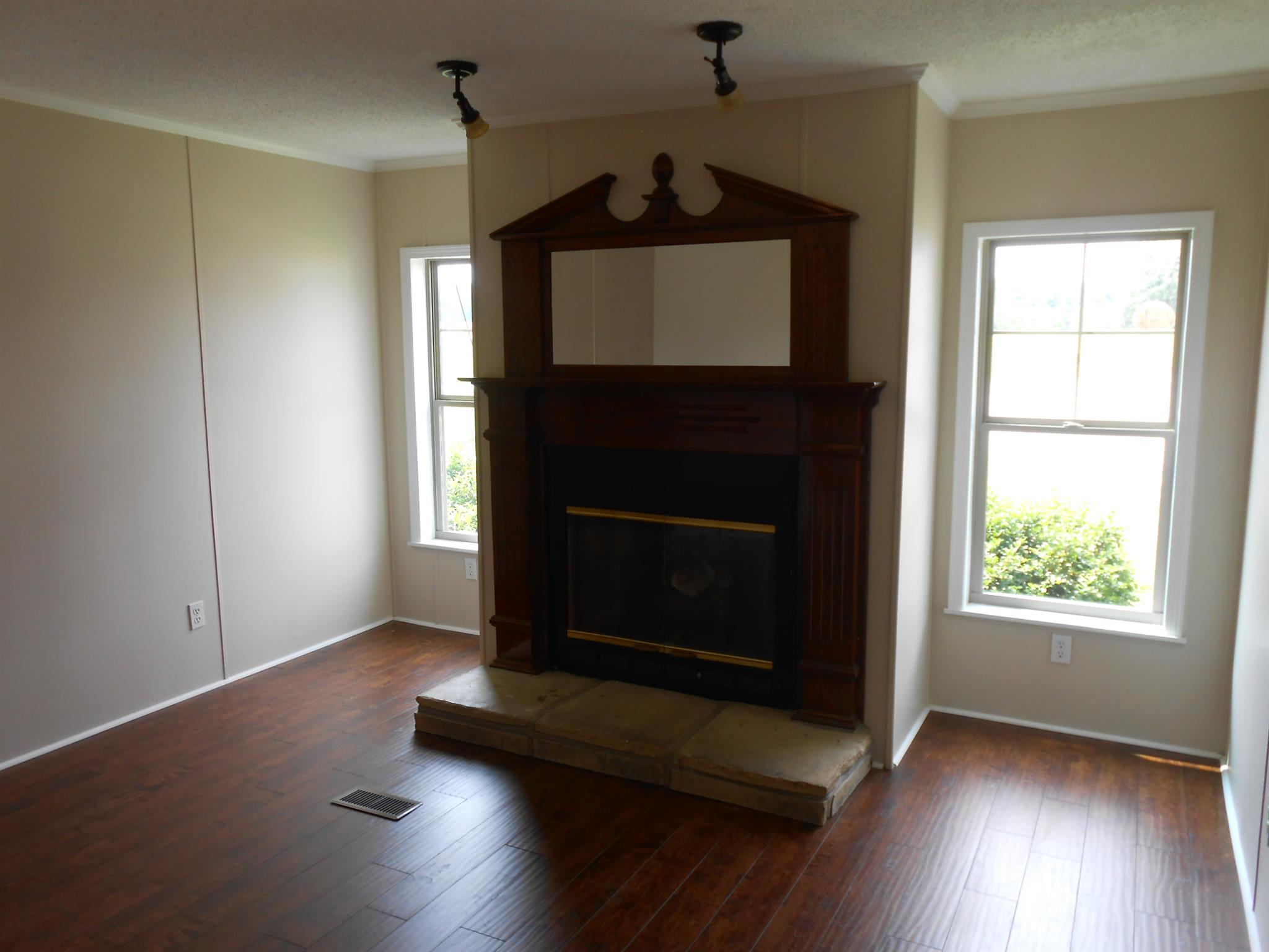 283 Freeland Road Portland, TN 37148 - Photo 11 of 21 a living room with wooden floor a fireplace and a window