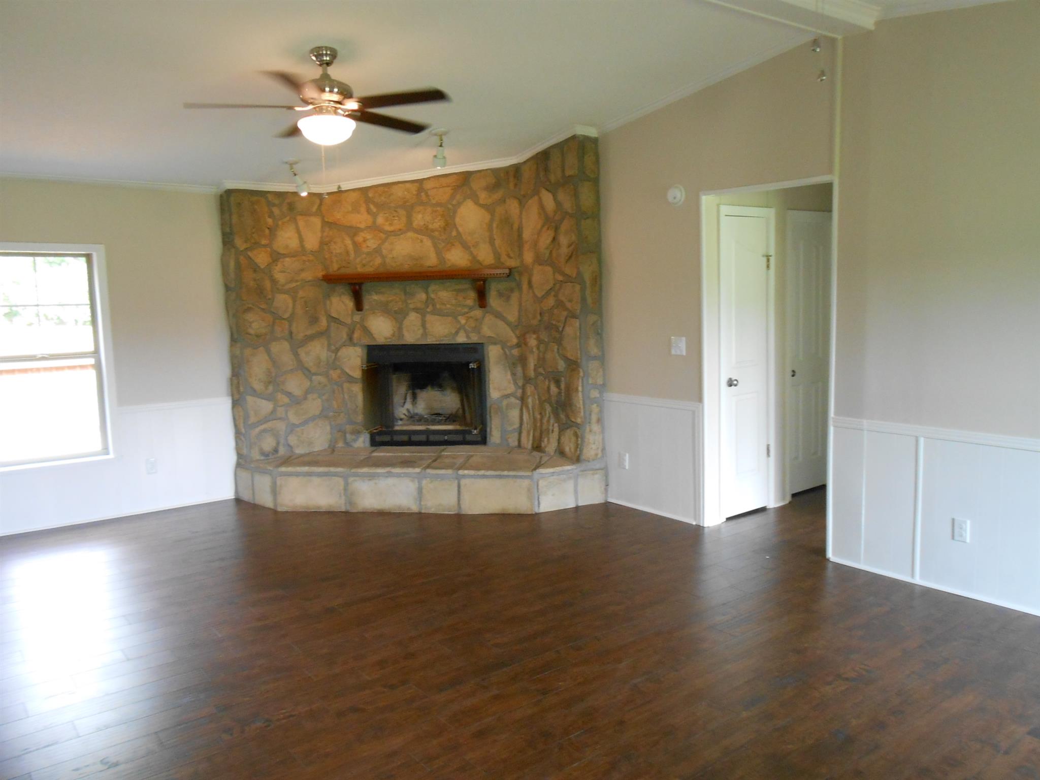 283 Freeland Road Portland, TN 37148 - Photo 6 of 21 a view of an empty room with wooden floor fireplace and a window