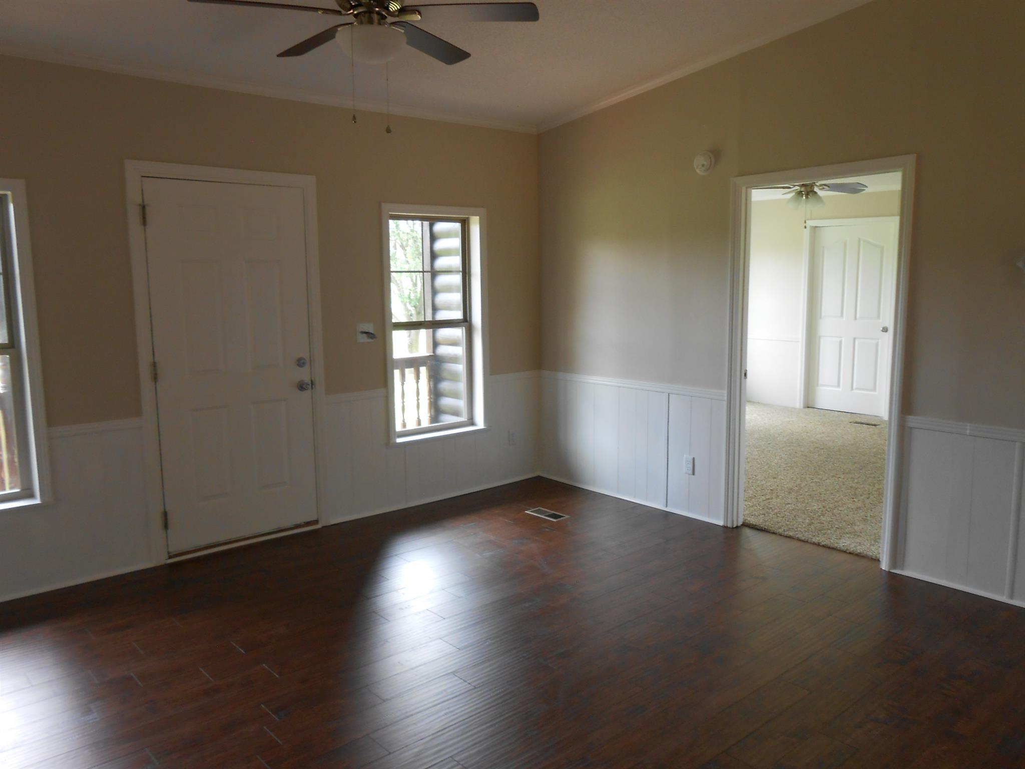 283 Freeland Road Portland, TN 37148 - Photo 7 of 21 an empty room with wooden floor chandelier fan and windows