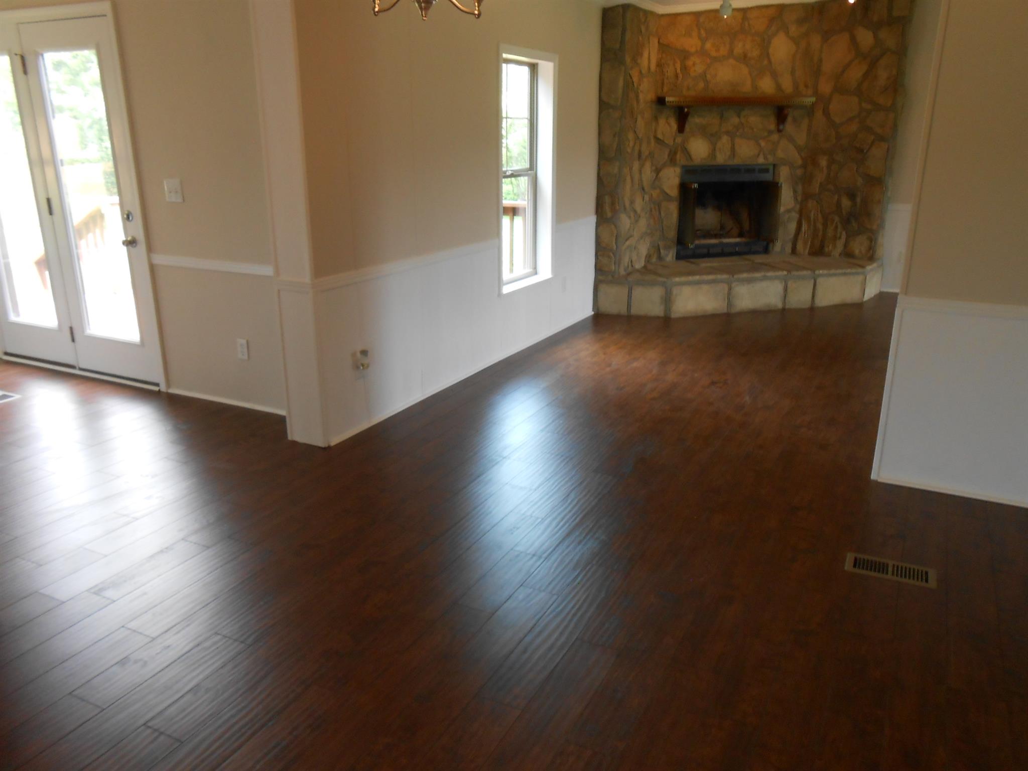 283 Freeland Road Portland, TN 37148 - Photo 10 of 21 an empty room with wooden floor fireplace and windows