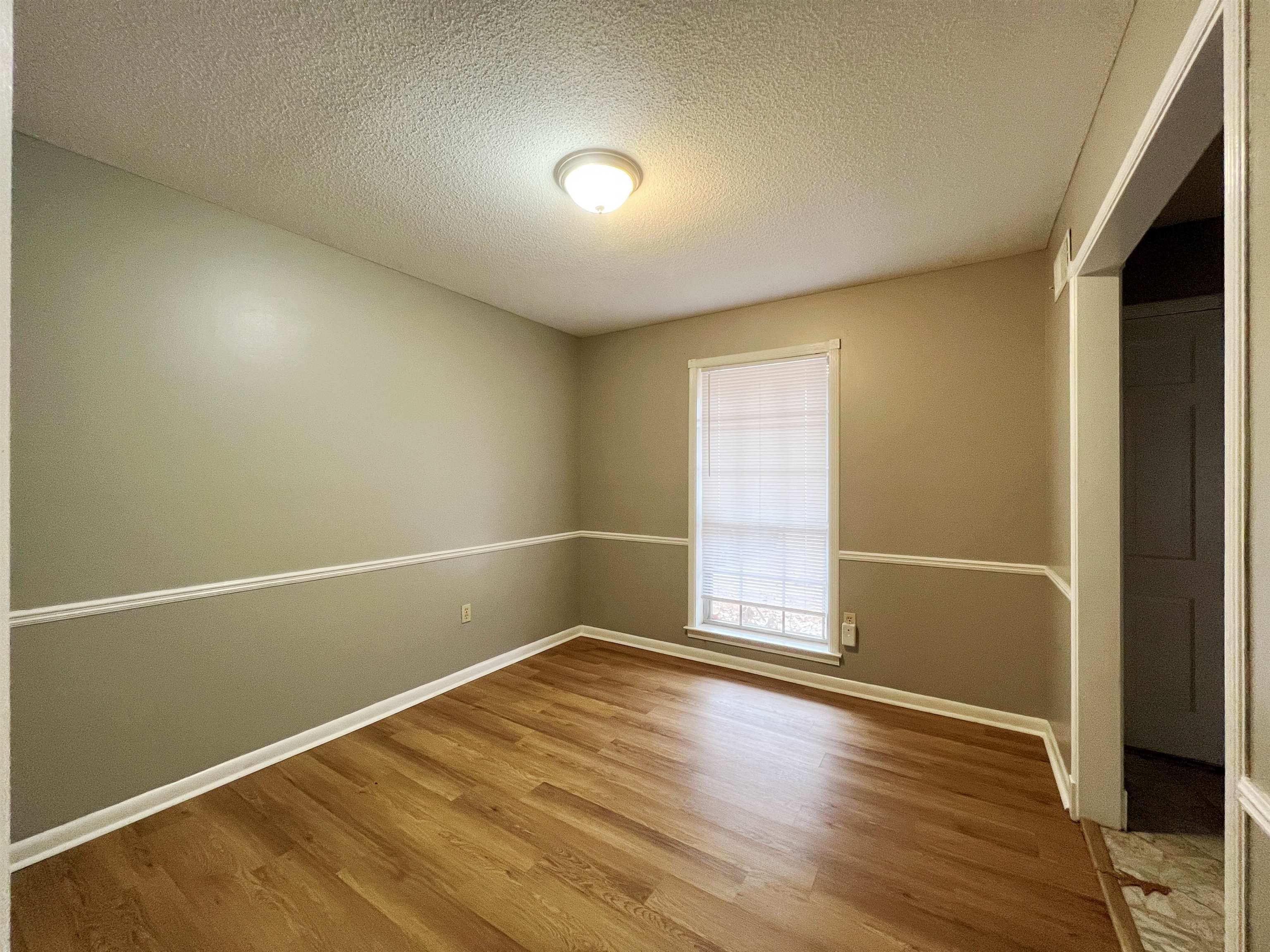 3169 Flint Drive Memphis, TN 38115 - Photo 5 of 13 an empty room with wooden floor and windows