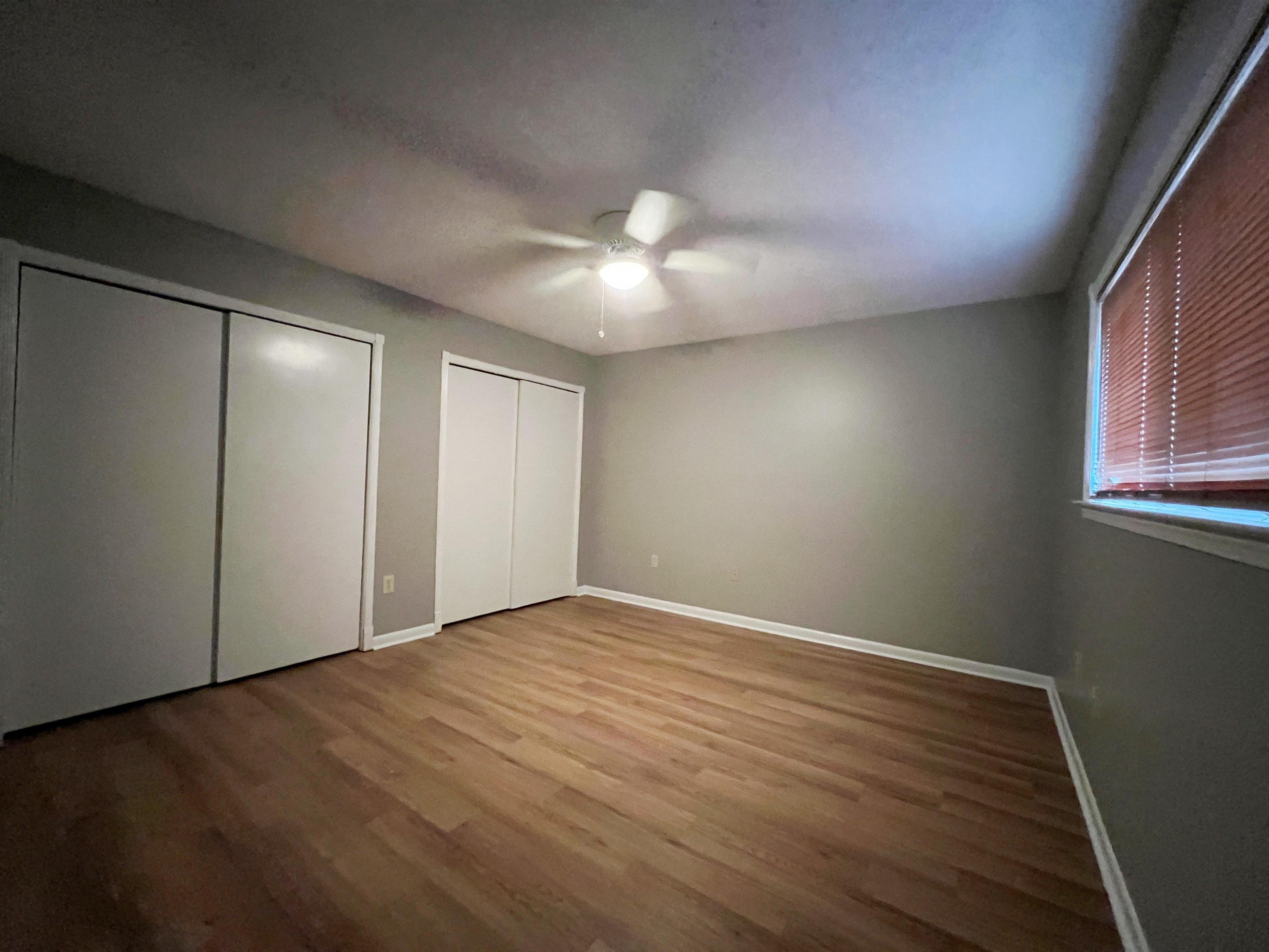 3169 Flint Drive Memphis, TN 38115 - Photo 10 of 13 an empty room with wooden floor and windows