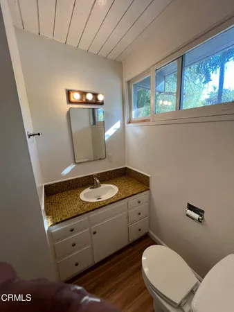 a bathroom with a granite countertop toilet sink and mirror