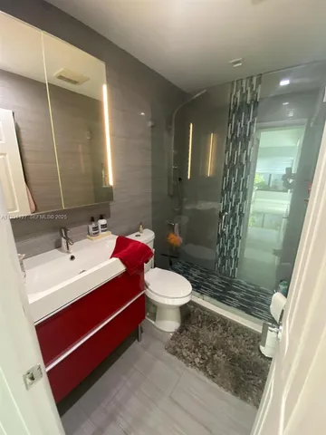 a bathroom with a sink a toilet and shower