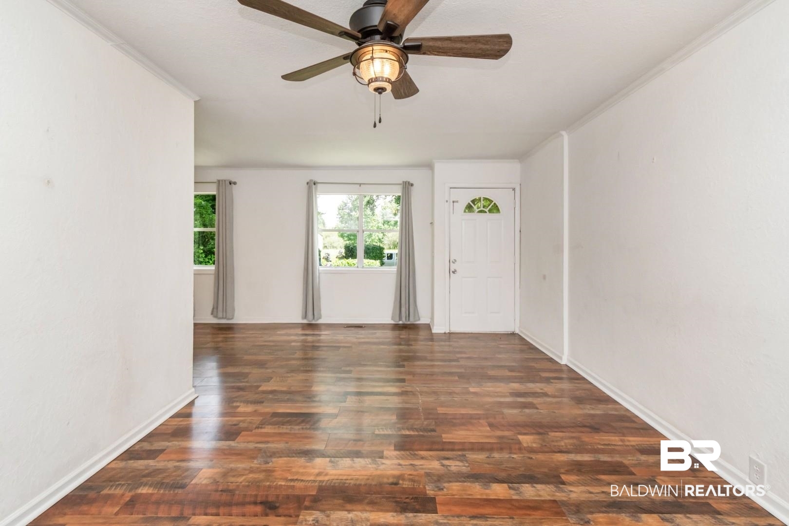 2905A McFarland Road, Unit F Mobile, AL 36695 - Photo 8 of 29 Spacious room featuring wood-finish flooring, white walls, and a ceiling fan with integrated lighting