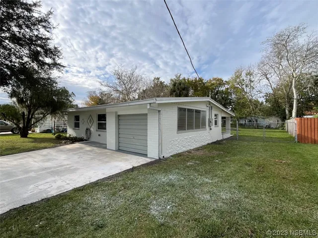 a view of a house with backyard and trees