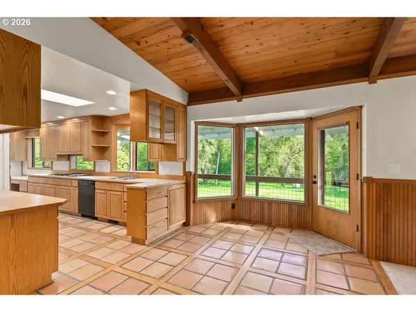 a room with kitchen island granite countertop a stove a sink and cabinets