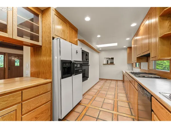 a kitchen with stainless steel appliances kitchen island granite countertop a refrigerator and stove