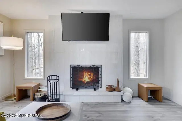 a living room with furniture a fireplace and a flat screen tv