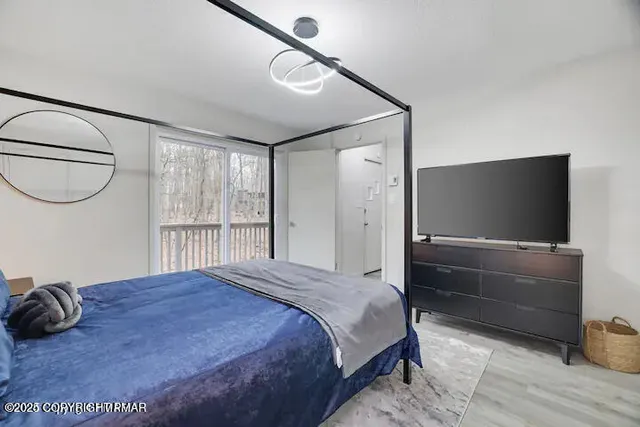 a bedroom with a bed and a flat screen tv