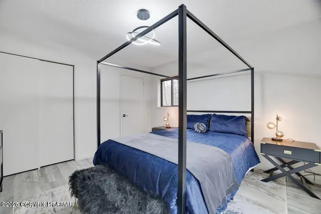 a bedroom with a bed window and a table