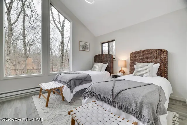 a bedroom with two beds and a large window