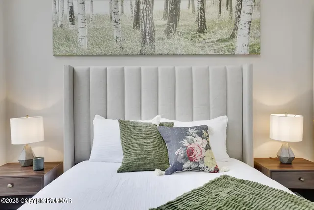 a bedroom with a bed and painting on the wall