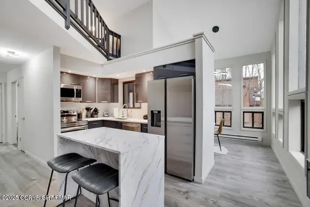 a kitchen with stainless steel appliances a refrigerator and a stove top oven