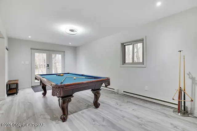 a room with pool table and windows